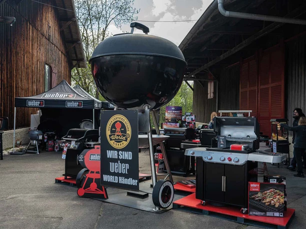 FIRE&FOOD BBQ WEEK An event for barbecue fans with a Weber barbecue and barbecue accessories on a paved courtyard.