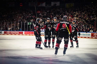 Kölner Haie Five Cologne Sharks ice hockey players in full gear on the ice in the Lanxess Arena.