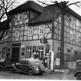 Hotel Tonne Historisches Fachwerkgebäude mit antiken Autos davor; das Hotel Tonne-Logo ziert die Wand.