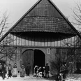 Ohle Geesken Historischer Bauernhof im Fachwerkstil mit Personen und einer Kuh vor dem großen Tor.