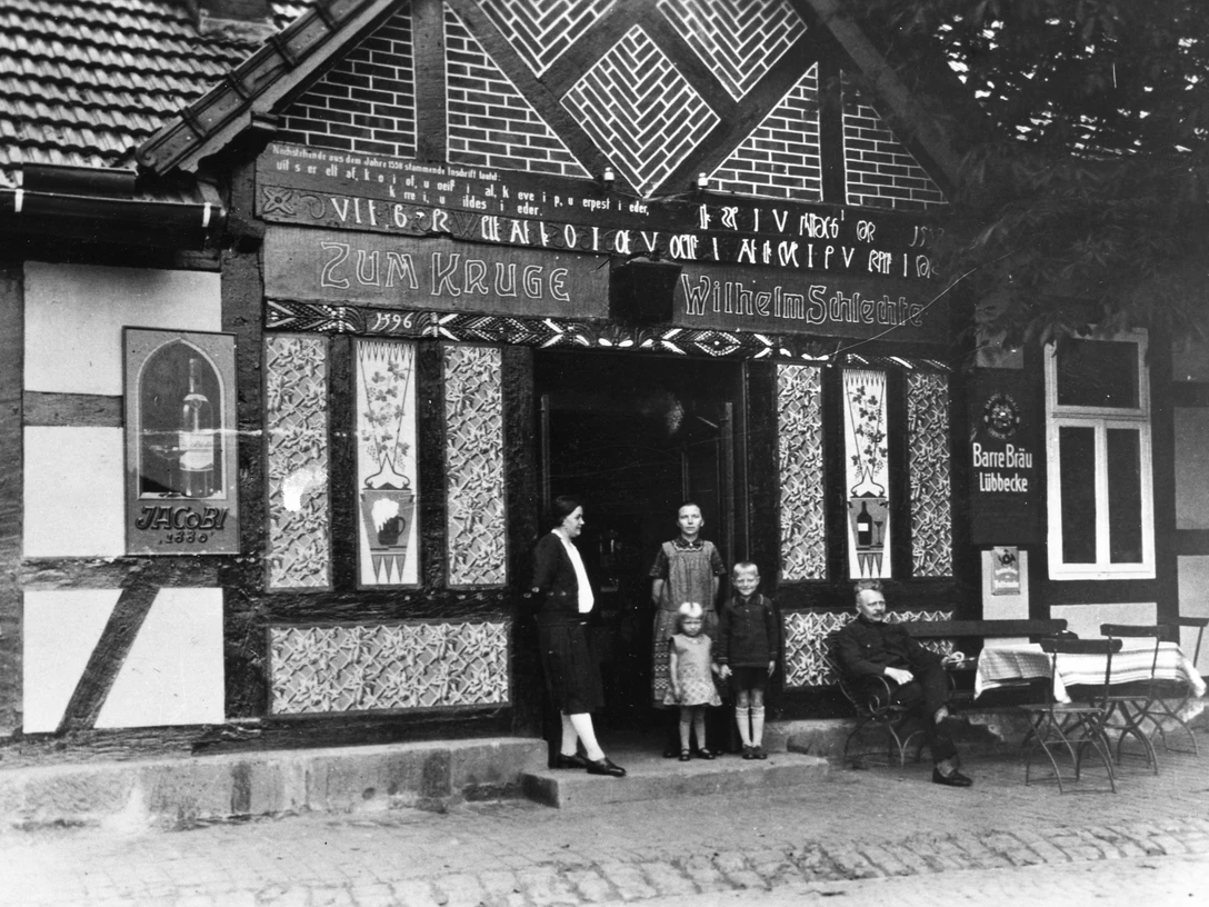 Lahder Krug Historische Schwarz-Weiß-Aufnahme des Gasthofes Lahder Krug mit drei Personen im Eingang.