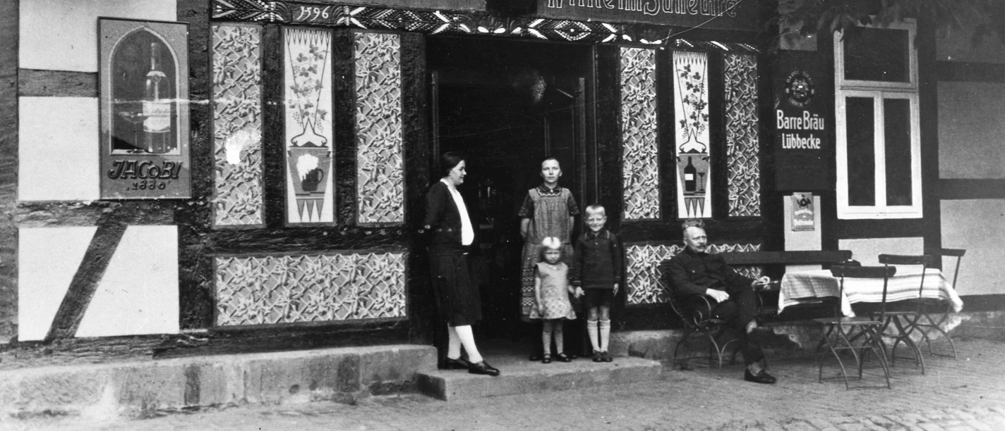 Lahder Krug Historische Schwarz-Weiß-Aufnahme des Gasthofes Lahder Krug mit drei Personen im Eingang.