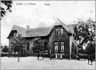 Alte Volksschule Historisches Backsteingebäude einer früheren Volksschule mit mehreren Fenstern und einem Schieferdach.