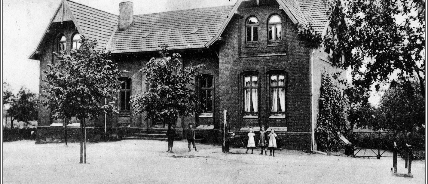 Alte Volksschule Historisches Backsteingebäude einer früheren Volksschule mit mehreren Fenstern und einem Schieferdach.