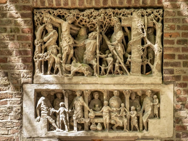 St. Alban Der steinerne Relief zeigt biblische Szenen auf einer rotbraunen Backsteinwand mit detaillierten Schnitzereien.