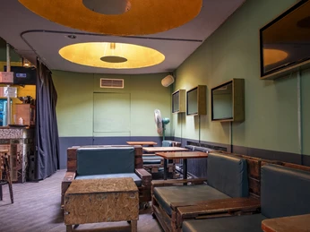 artheater Der geschmackvoll eingerichtete Raum des Artheaters präsentiert sich mit gedämpftem Licht und modernem Interieur, das durch warme Farbtöne dominiert wird.The tastefully furnished room of the Artheater presents itself with subdued lighting and a modern interior dominated by warm colors.