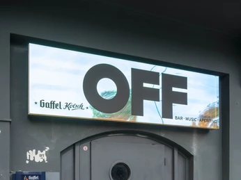 OFF Bar An einer dunklen Tür prangt ein schlichtes OFF-Schild. Graffiti schmücken die Wand.A simple OFF sign is emblazoned on a dark door. Graffiti adorns the wall.