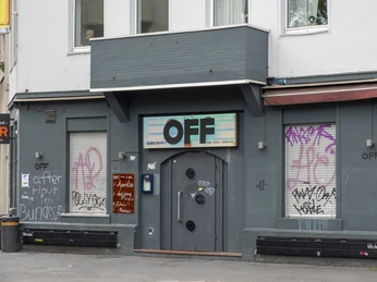 OFF Bar Die graue Fassade der Off-Bar in Köln ist mit buntem Graffiti verziert, zwei Ankerpunkte der urbanen Kultur.The gray façade of the Off-Bar in Cologne is decorated with colorful graffiti, two anchor points of urban culture.