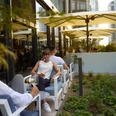 Lazuli Bar & Kitchen - Terrasse Person sitzt auf einer Terrasse und genießt ein Getränk.