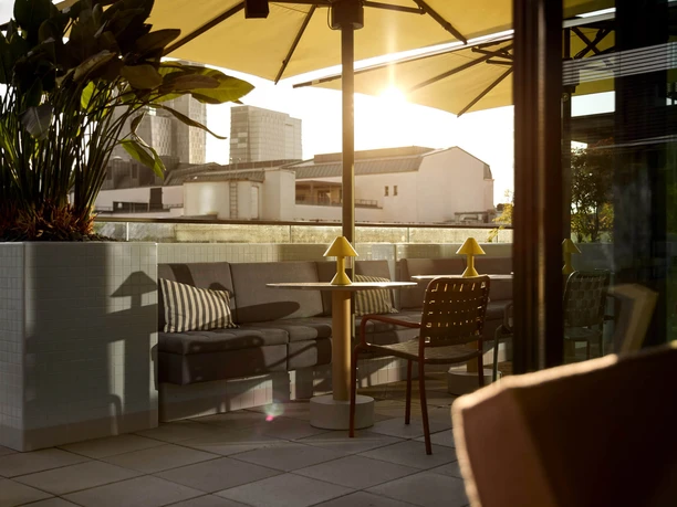 Lazuli Bar & Kitchen - Terrace Cozy terrace with sofas at sunset.