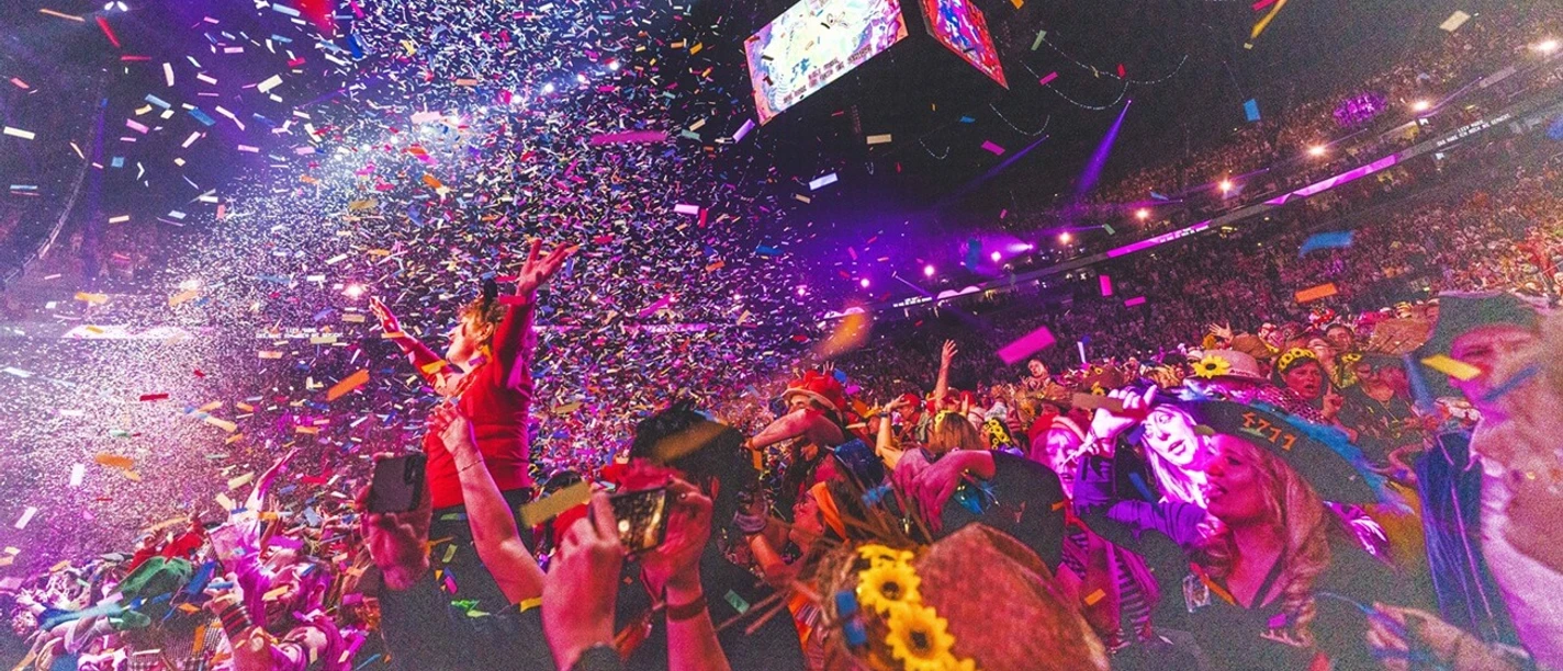 Lachende Kölnarena Amidst a glittering shower of confetti and glowing lights, a large crowd celebrates exuberantly in the LANXESS arena. Colorful wreaths of flowers and cheerful faces in front of a radiant stage testify to a festive atmosphere and an unforgettable event.