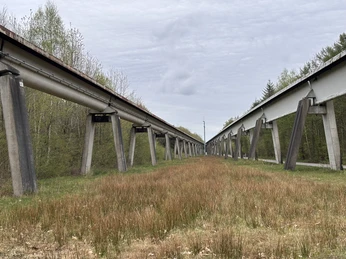 Transrapid-Versuchsanlage Emsland, Lathen - Teststrecke_quer ©Emsland Tourismus GmbH.JPEG Blick auf die erhöhte Transrapid-Teststrecke bei Lathen, umgeben von Wiesen und jungen Bäumen.