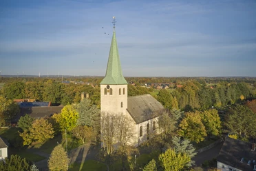 St. Katarina in Voltlage Landschaftsansicht mit Kirchturm und herbstlichen Bäumen aus der Vogelperspektive.