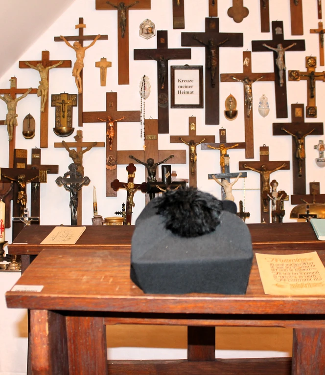 Heimatmuseum Langen – Blick auf Kreuze und Heiligenbilder, Ausstellung 2006 ©Emsland Tourismus GmbH .JPG Holzaltar mit religiösen Figuren und vielen Kreuzen an der Wand im Heimatmuseum Langen