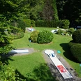 Minigolf Binder_01_Stadt Velbert_Lisa Krick.JPG Eine Minigolfanlage eingebettet in grüne Hecken und Rasenflächen, mit mehreren Bahnen und schattigen Ecken.