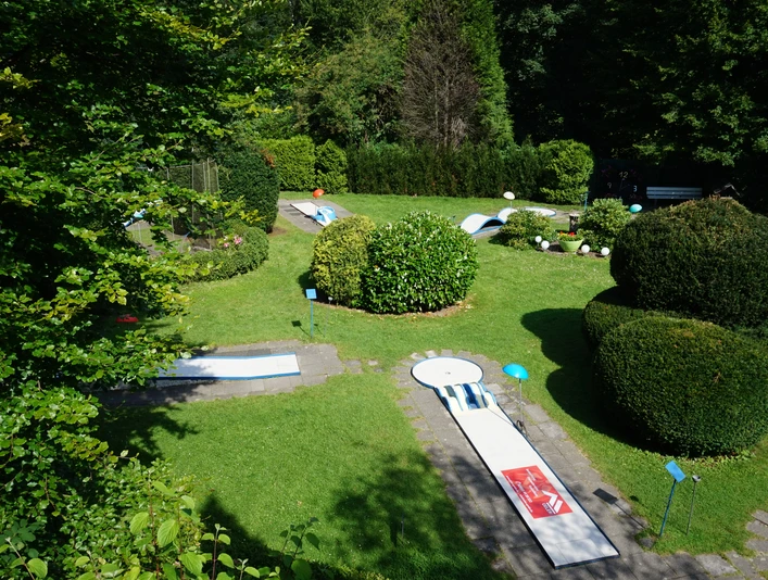 Minigolf Binder_01_Stadt Velbert_Lisa Krick.JPG Eine Minigolfanlage eingebettet in grüne Hecken und Rasenflächen, mit mehreren Bahnen und schattigen Ecken.