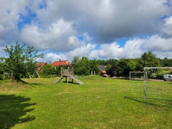 Spielplatz_in_Bispingen_am_Droegenberg.jpg Spielplatz iSpielplatz in Bispingen am Drögenberg mit Klettergerüst, Rutsche und Fußballtor auf großer Wiese unter blauen Himmel