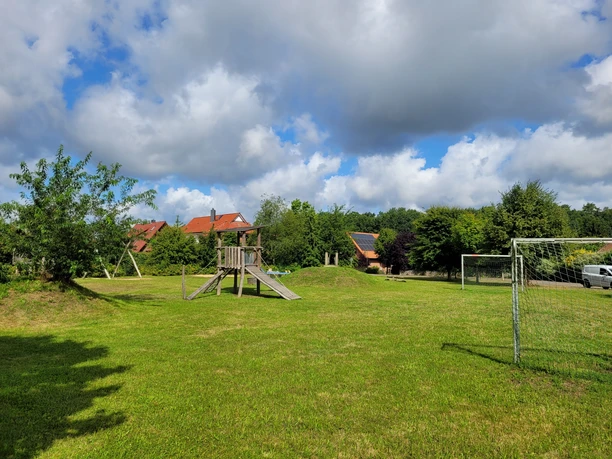 Spielplatz_in_Bispingen_am_Droegenberg.jpg Spielplatz iSpielplatz in Bispingen am Drögenberg mit Klettergerüst, Rutsche und Fußballtor auf großer Wiese unter blauen Himmel