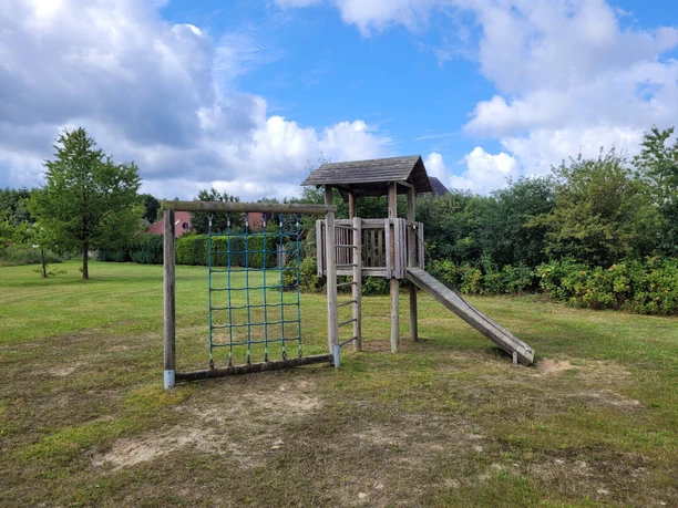 Spielplatz in Bispingen am Drögenberg mit Klettergerüst aus Holz, Netz zum Klettern unter blauem Himmel