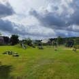 Spielplatz_in_Bispingen_am_Droegenberg__03.jpg Spielplatz in Bispingen am Drögenberg mit Rutsche, Schaukel, Wippe auf einer großen Wiese unter bewölktem Himmel
