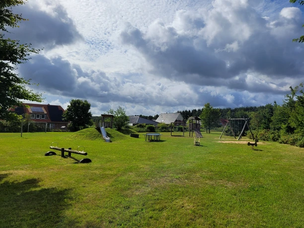 Spielplatz_in_Bispingen_am_Droegenberg__03.jpg Spielplatz in Bispingen am Drögenberg mit Rutsche, Schaukel, Wippe auf einer großen Wiese unter bewölktem Himmel