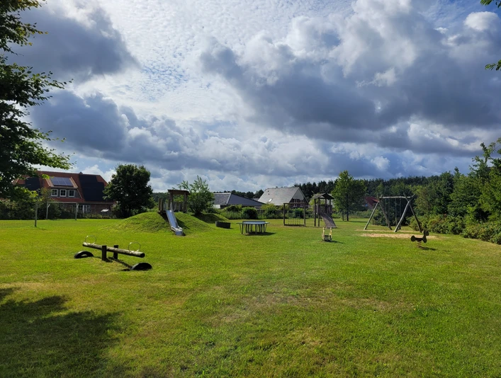 Spielplatz_in_Bispingen_am_Droegenberg__03.jpg Spielplatz in Bispingen am Drögenberg mit Rutsche, Schaukel, Wippe auf einer großen Wiese unter bewölktem Himmel