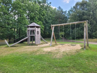 Spielplatz_am_Brunausee_.jpg pielplatz am Brunausee mit Holzturm, Kletterwand, Seilrutsche und Doppelschaukel auf Grasfläche