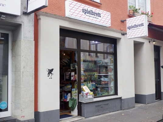 Spielbrett, exterior view of the store Außenansicht eines kleinen Ladens mit dem Namen "Spielbrett", der eine breite Auswahl an Brettspielen präsentiert.Exterior view of a small store called "Spielbrett", which presents a wide selection of board games.