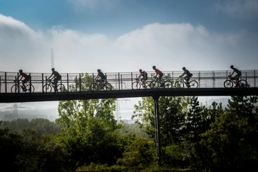 Eine Gruppe Gravelbikende auf der Promenadenbrücke der Halde Hoheward