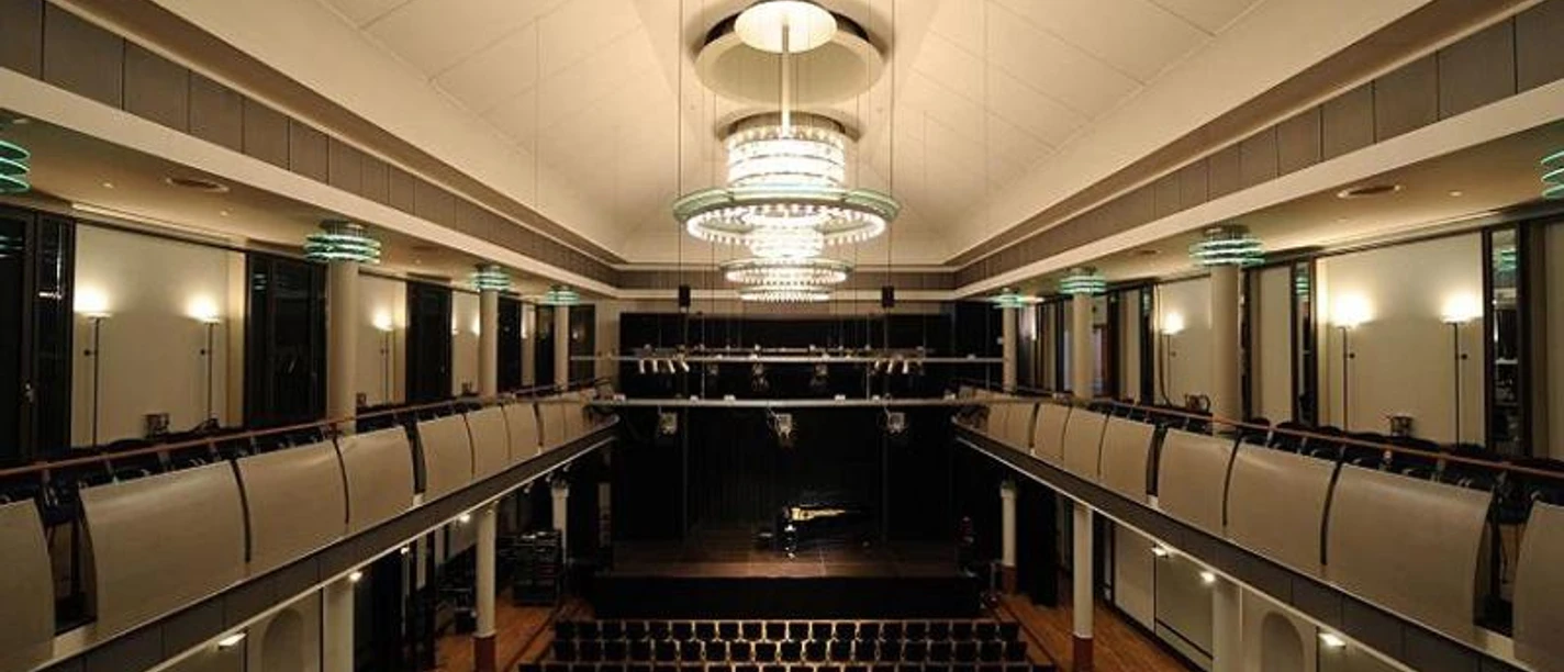 Frankfurter Hof Mainz Großer, modern beleuchteter Saal mit Balkonen, Bestuhlung und Bühne.