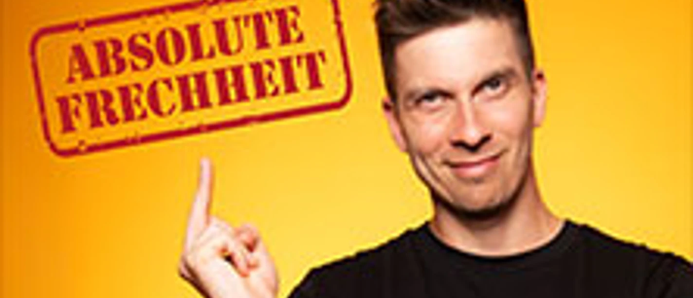 Porträt von Simon Stäblein im schwarzen T-Shirt vor einem gelben Hintergrund, Text "Absolute Frechheit".
