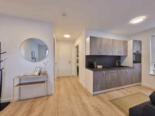 Wohnraum Moderner Wohnraum mit offener Küche, Holzboden und stilvoller Dekoration in neutralen Farbtönen.