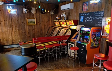Skeeball and arcade games in the Red Fox Bar A rustic bar with wooden walls, arcade games, red bar stools and a relaxed atmosphere.