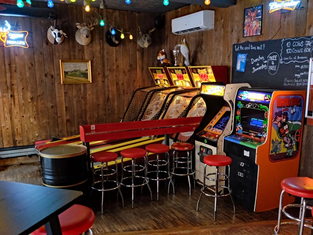 Skeeball and arcade games in the Red Fox Bar A rustic bar with wooden walls, arcade games, red bar stools and a relaxed atmosphere.
