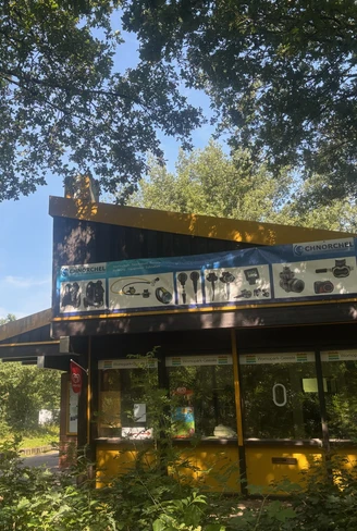 IMG_2891.jpg Gebäude mit gelbem Dach und Tauchschule im Grünen am Womopark Geeste bei sonnigem Wetter