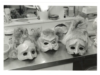 200 Jahre Theater Aachen_Masken zu der Oper - Neues vom Tage (c) Stadt Aachen.jpg Schwarz-weiß Foto von verschiedenen Theatermasken auf einem Tisch mit einem Spiegel dahinter.