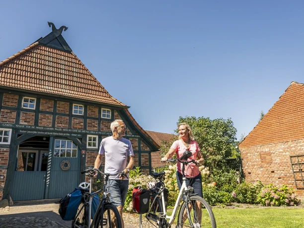 Cyklist foran et bindingsværkshus i Wilstedt