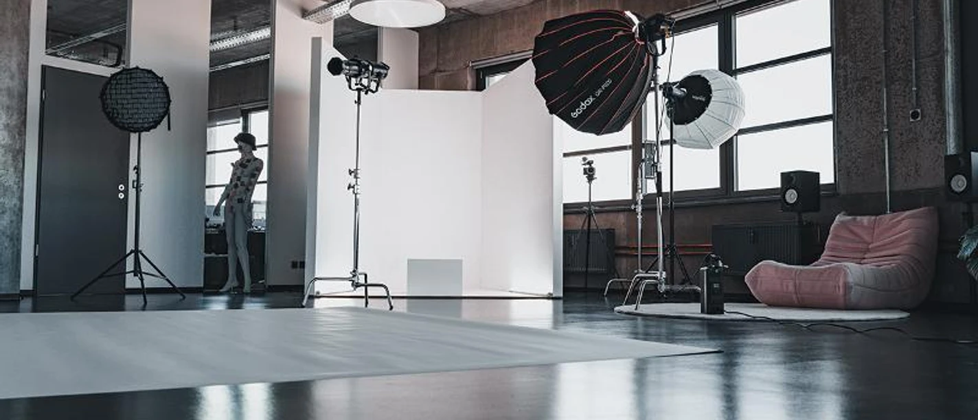 LOWKY Studio Großes, modernes Fotostudio mit Ausrüstung, grauen Wänden und einem Mannequin.
