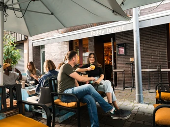 Toddy Tapper Das Toddy Tapper in Köln mit entspannter Atmosphäre, Menschen genießen Getränke im Außenbereich.The Toddy Tapper in Cologne with a relaxed atmosphere, people enjoying drinks in the outdoor area.