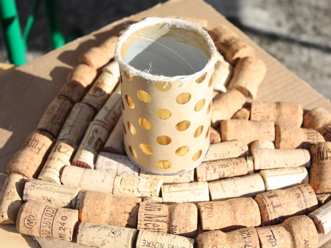 Upcycling Eine selbstgebastelte Tischdeko aus Korken und einer goldenen Blechdose.