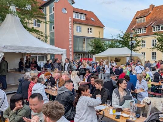 Weinfest Vlotho 2025 Viele Menschen auf Bierzeltgarnituren. Pavillons und Weinstände
