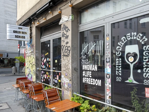 Zum Goldenen Schuss Pub with graffiti-decorated windows that reflect modern urban culture.