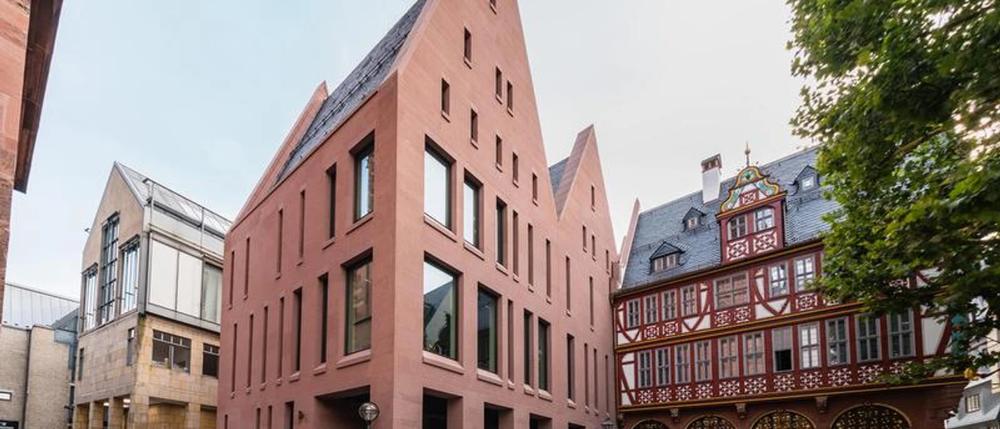 Stadthaus Frankfurt © TASTE OF NOW GmbH.jpg Das moderne Stadthaus Frankfurt mit Giebeln neben historischen Gebäuden.