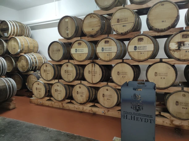 Private Kornbrennerei H. Heydt, Haselünne ©Emsland Tourismus GmbH (9).jpg Holzfässer der Kornbrennerei H. Heydt lagern in Reihen auf Holzgestellen in einem modernen Reiferaum.