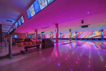 Bowling lanes at West Bowling A modern bowling hall with colorful LED lighting, glowing lanes and colorful balls.