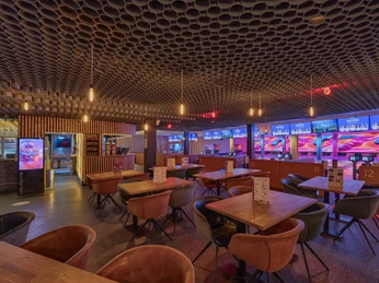 Bar area at West Bowling Großräumige Bowlingbahn mit modernen Lichteffekten und Barbereich mit stilvoller, gemütlicher Sitzgelegenheit.Spacious bowling alley with modern lighting effects and bar area with stylish, cozy seating.