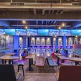 Bowling Bahnen im Underlux Interieur des Underlux Bowlingcenters mit blauen und violetten Lichtern, Tische im Vordergrund.Interior of the Underlux bowling center with blue and purple lights, tables in the foreground.