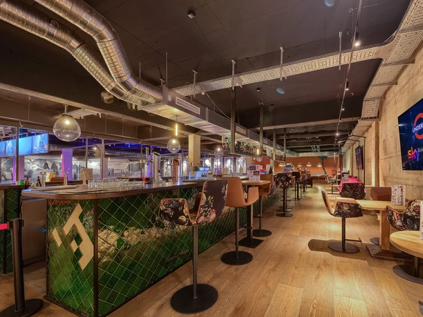 Underlux Bowling Ein modernes Bowlingzentrum in Köln mit beleuchteter Bar, stilvollem Interieur und gemütlichen Sitzbereichen.