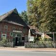 Zaika Restaurant und Tapas Bar von außen Fachwerkhaus mit Reetdach und grünen Balken, davor Terrasse mit Sonnenschirmen und Blumen.