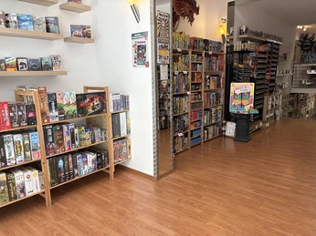 Insight into the entrance area of the Brave New World Blick in das Brave New World mit Konsolen vor prall gefüllten Wandregalen voller bunter Spiele.View of the Brave New World store with consoles in front of bulging wall shelves full of colorful games.